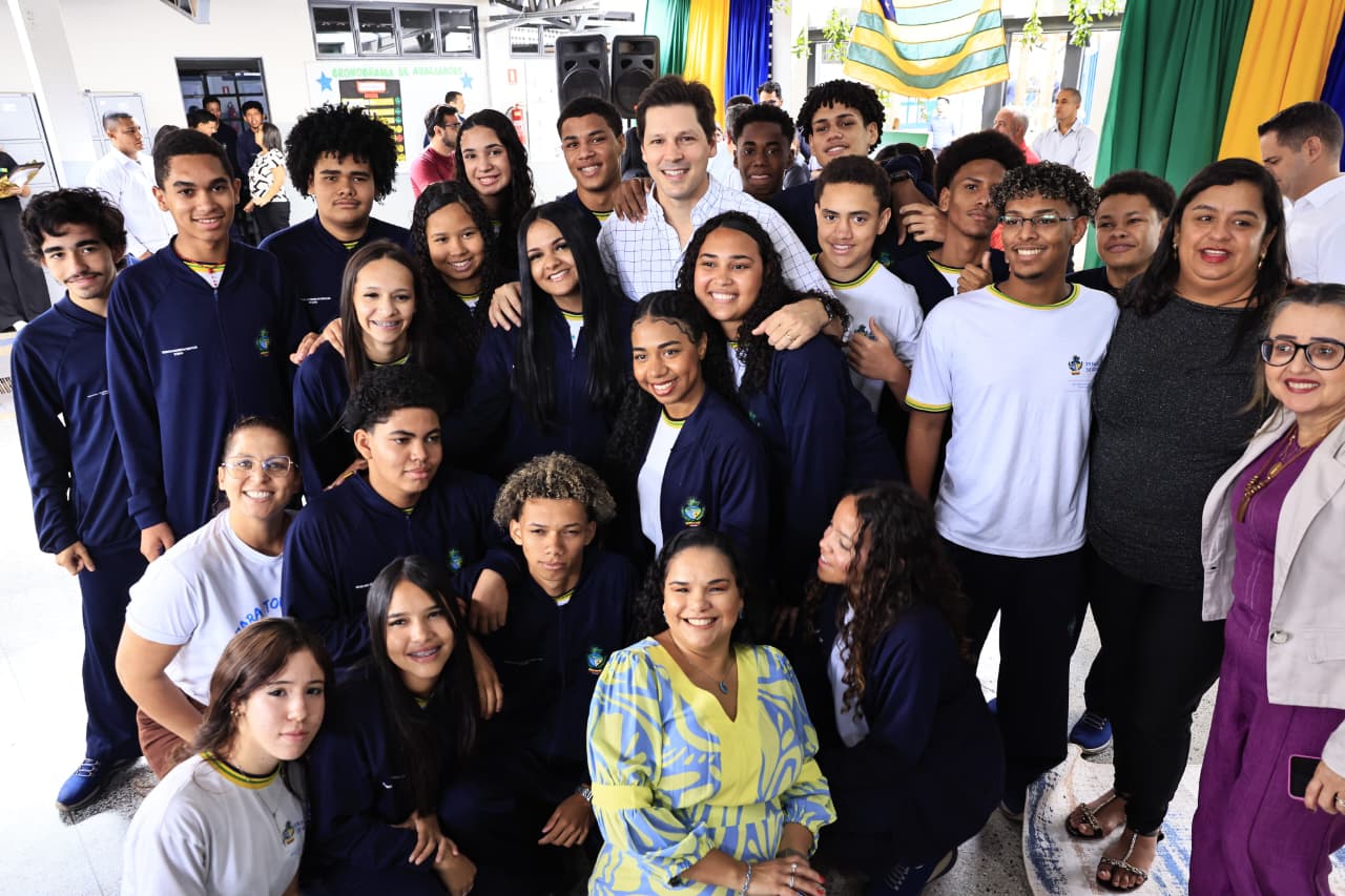 Daniel Vilela rodeado de alunos e professores do colégio em Aparecida de Goiânia.
